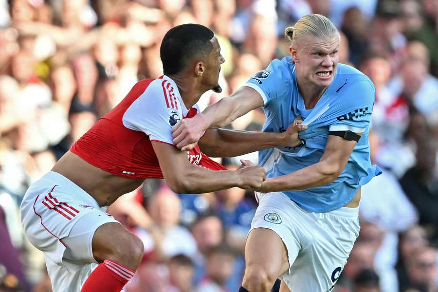 Arsenal defender William Saliba (L) fights for the ball with Manchester City striker Erling Haaland Arsenal defender William Saliba (L) fights for the ball with Manchester City striker Erling Haaland