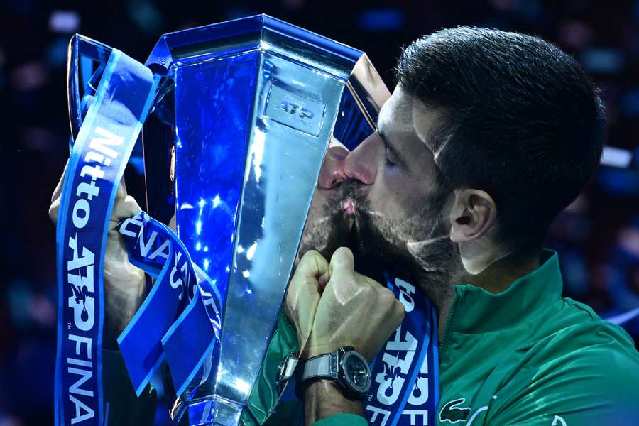 Novak Djokovic kisses the trophy after winning the final against Jannik Sinner