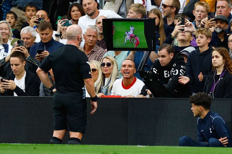 El árbitro Simon Hooper mira el monitor del VAR antes de mostrar la tarjeta roja a Curtis Jones, del Liverpool. 