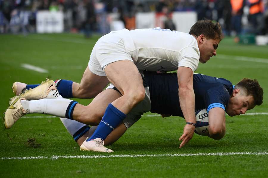 Scotland's centre Huw Jones (R) scores a try as France's scrum-half Antoine Dupont (L) attempts to tackle