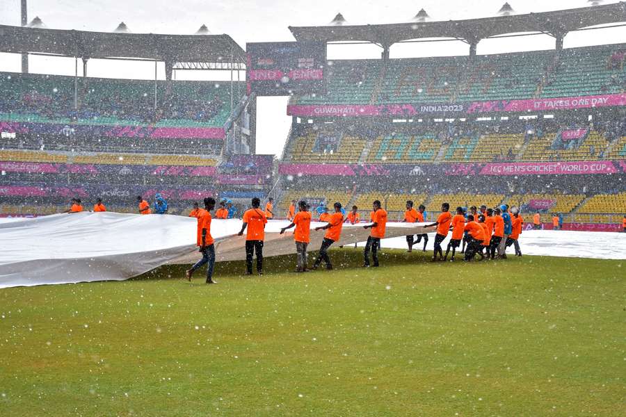 O relvado está coberto enquanto a chuva abandona o jogo de aquecimento no Estádio da Associação de Críquete de Assam em Guwahati