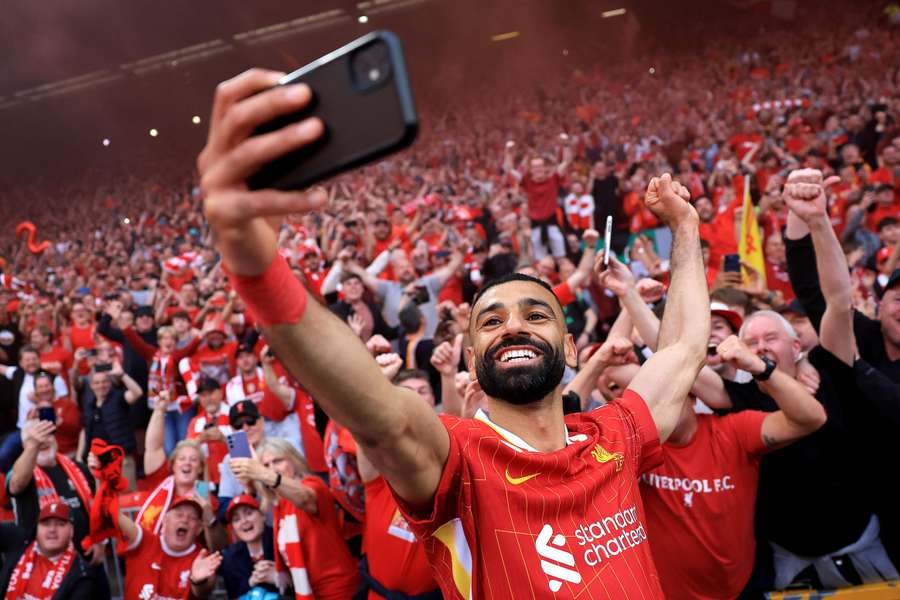 Liverpool's Mohamed Salah takes a selfie with the fans as they celebrate the team's victory and confirmation of winning the Premier League title