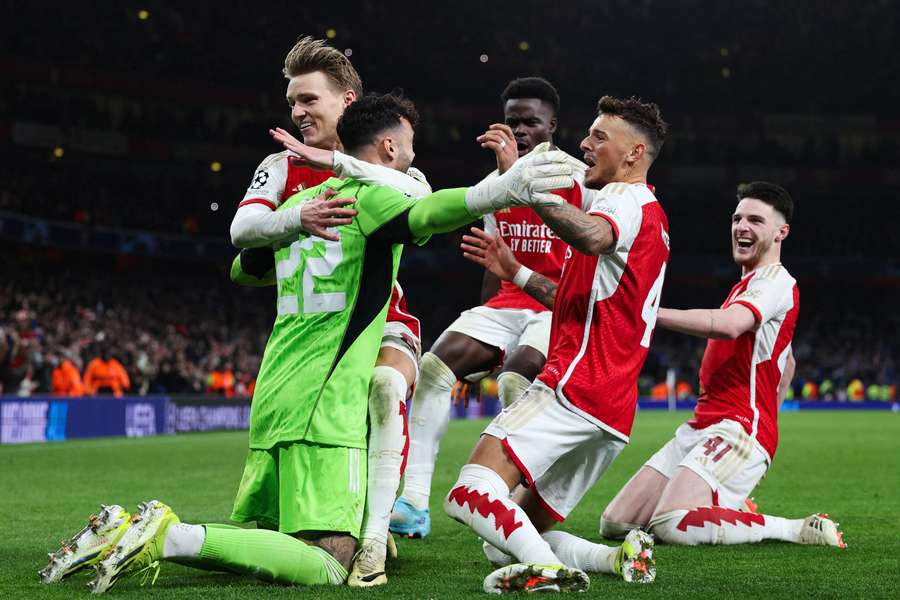 Arsenal players celebrate with hero David Raya