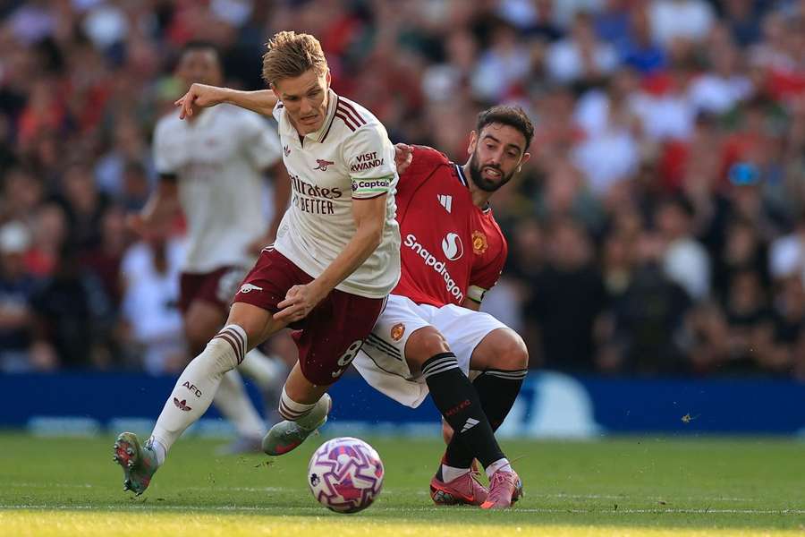 Martin Odegaard de la Arsenal este blocat de Bruno Fernandes de la Man Utd