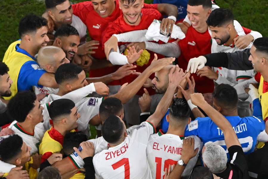 Morocco's players tap the head of their manager  when celebrating their win