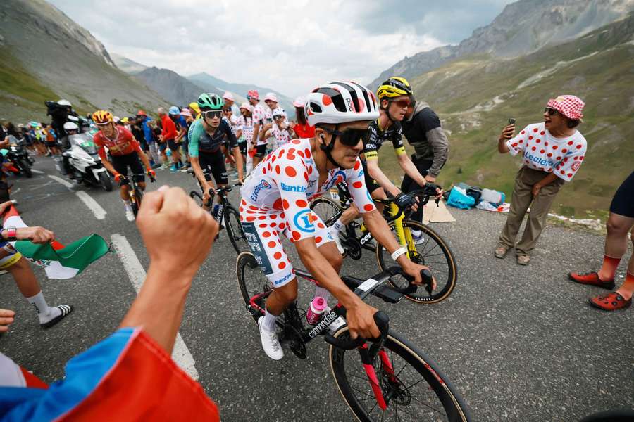 EasyPost's Richard Carapaz wearing the polka dot jersey and other cyclists in action as spectators watch during stage 20 on Saturday