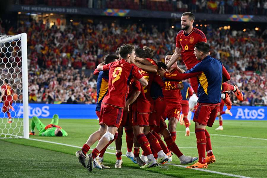 Spain's players celebrate after winning the penalty shootout