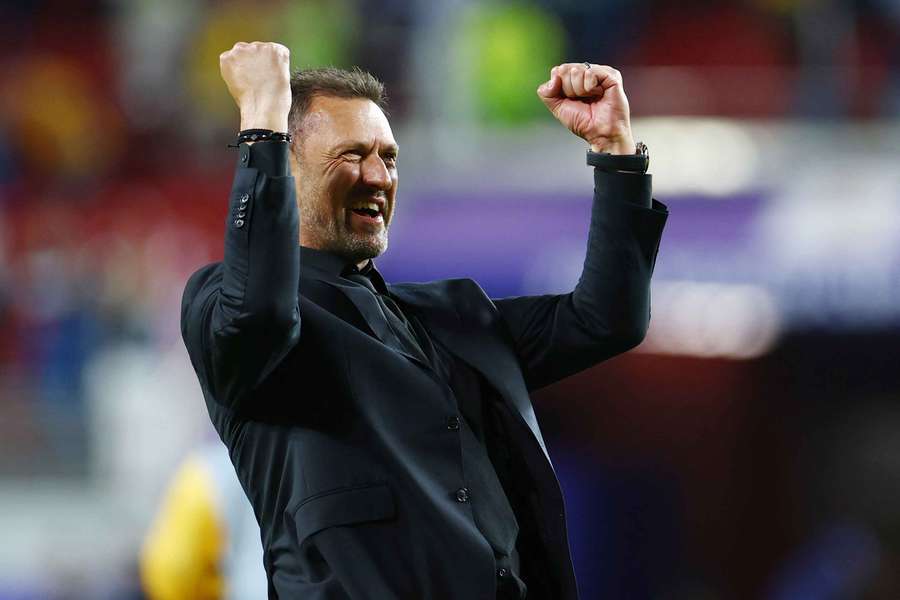 Australia manager Tony Popovic celebrates his team's progression to the Round of 32. Australia manager Tony Popovic celebrates his team's progression to the Round of 32.