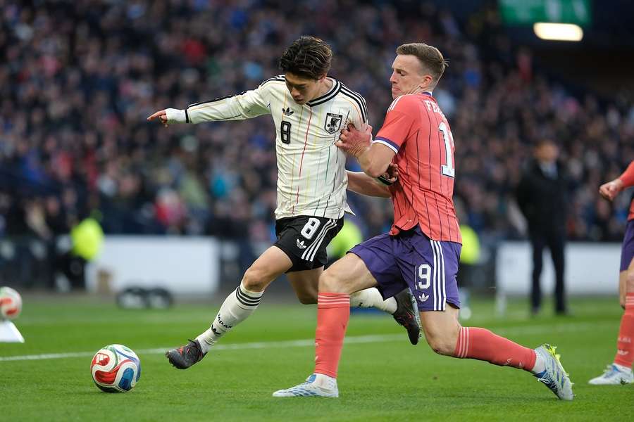Scotland's Lewis Ferguson (R) chases the ball