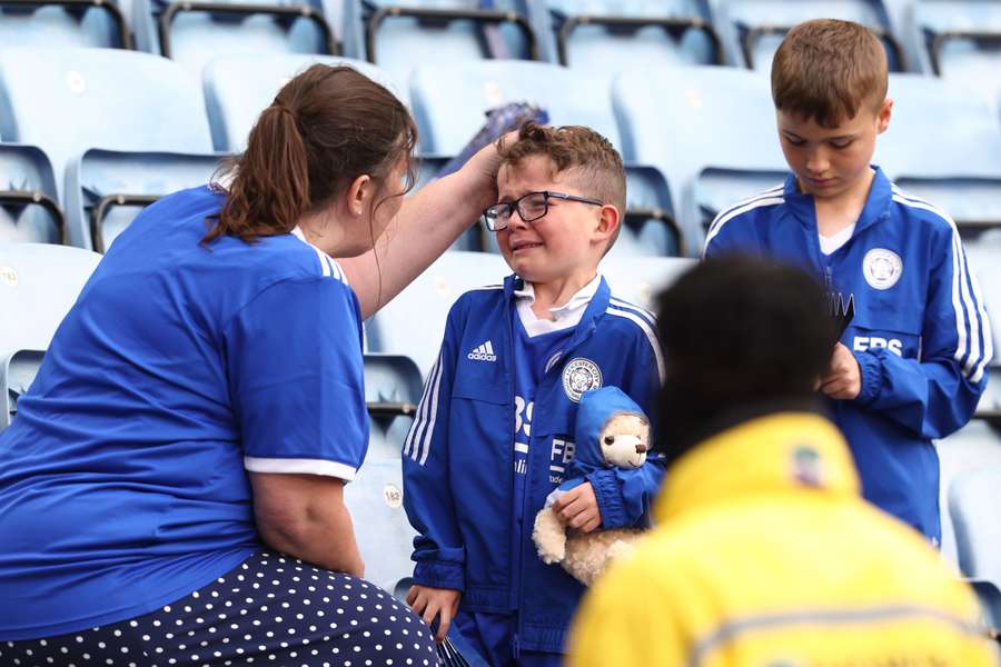 A Leicester City's fan is consoled at the end of the English Premier League football match between Leicester City and West Ham United