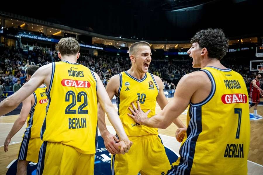 Tim Schneider (M.) bejubelt mit seinen Kollegen von Alba Berlin den Sieg gegen Mailand.