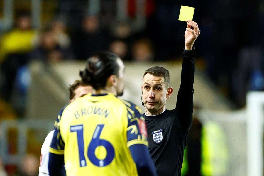 Ciaron Brown receives his booking during the FA Cup tie against Arsenal