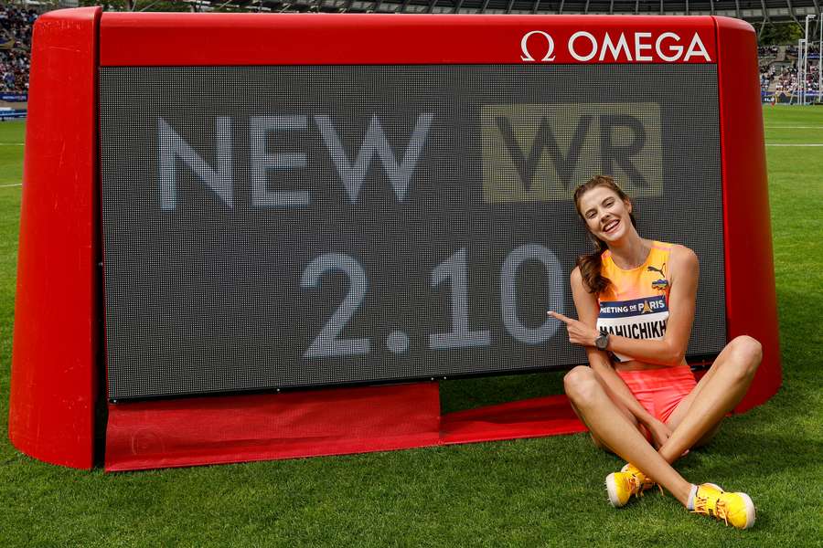 Mahuchikh poses in front of the board confirming her new record