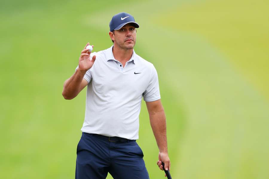 Brooks Koepka of the United States waves to the fans on the 18th green