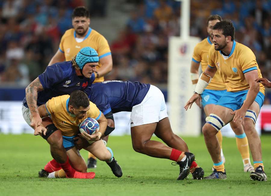 Uruguay's centre Agustin L Ormaechea (2ndL) is tackled by France's lock Bastien Chalureau (L) and France's prop Sipili Falatea