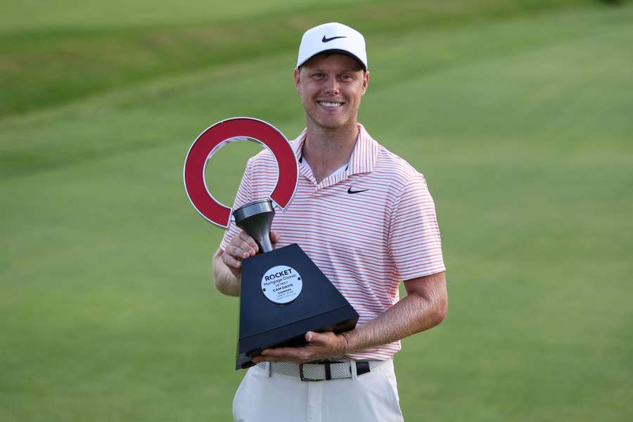 Cameron Davis celebrates with the trophy after winning his second PGA Rocket Mortgage Classic