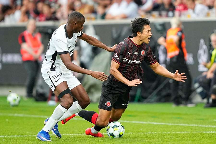 FC Midtjylland's South Korean forward Gue-sung Cho (R) is tackled by Besiktas's Portuguese defender Tiago Djalo