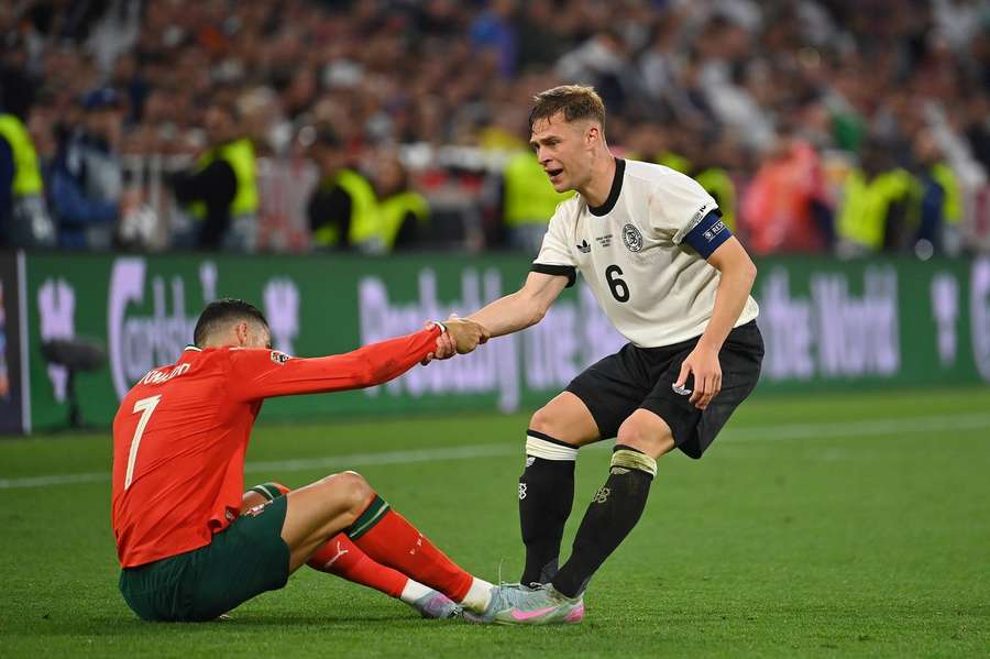 Kimmich (r.) hilft Ronaldo auf die Beine