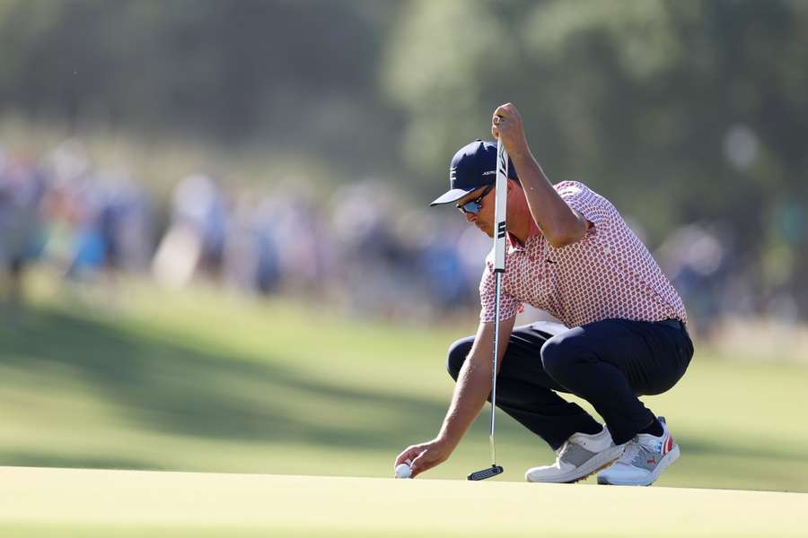 Rickie Fowler of the United States lines up a putt on the seventh green