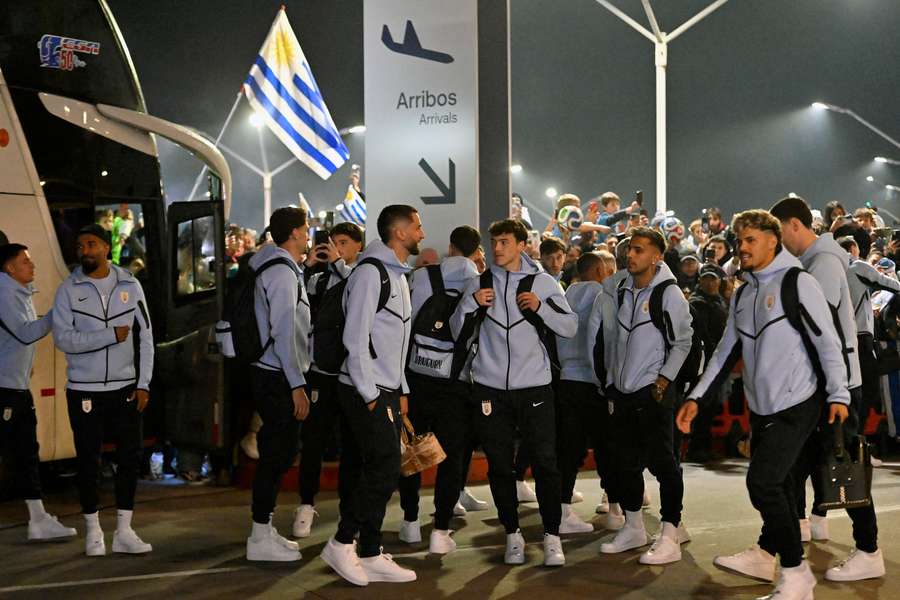 Grupo de jogadores do Uruguai sendo recepcionados por torcedores.