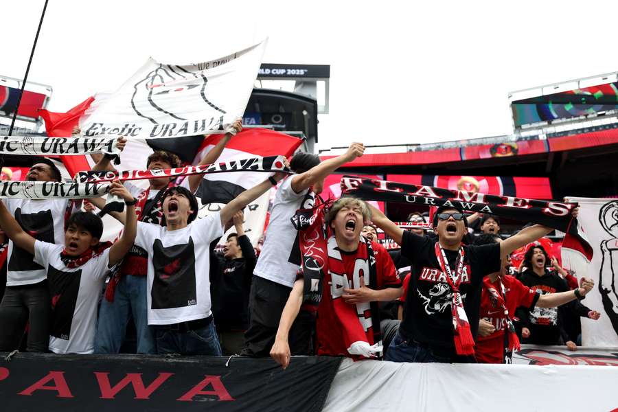 Os adeptos do Urawa Red Diamonds gritam pela sua equipa durante o jogo contra o Inter de Milão