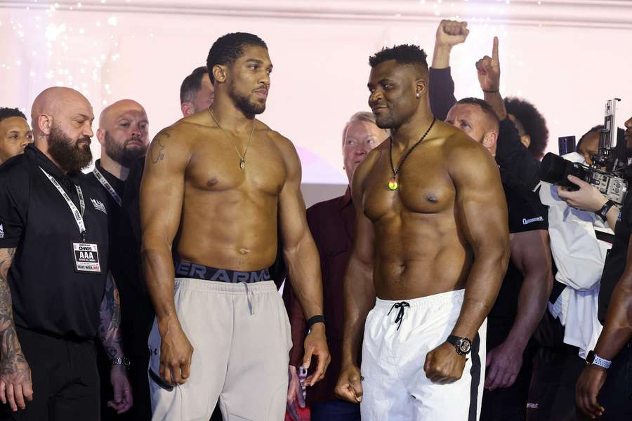 Anthony Joshua (L) and Francis Ngannou (R) interact at the weigh-in 