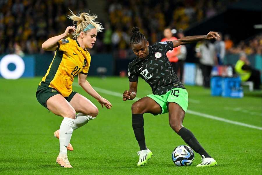 Ellie Carpenter of Australia (left) fights for the ball with Uchenna Kanu of Nigeria