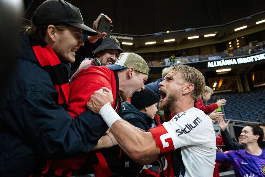 Le défenseur Strand célèbre la victoire avec les supporters.