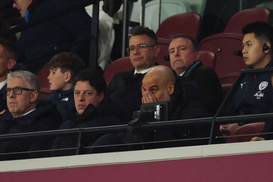 Pep Guardiola watches Manchester City's draw against West Ham from the stands.