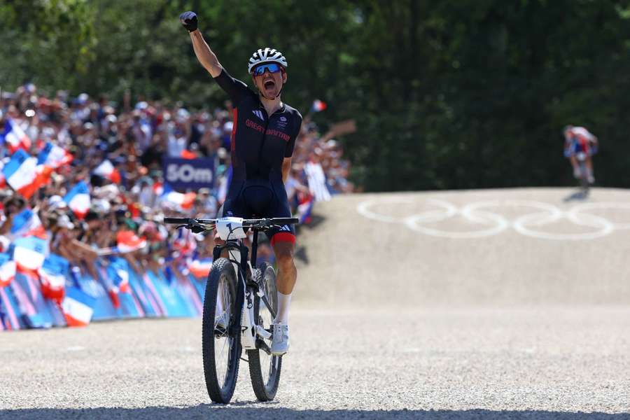 Tom Pidcock celebrates after crossing the line