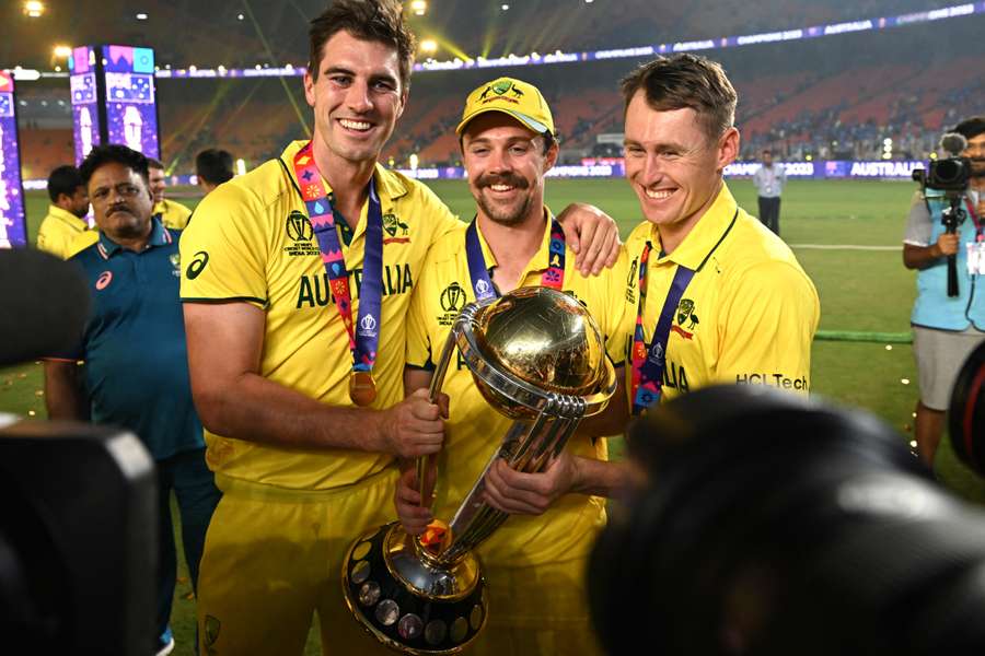 Australia captain Pat Cummins (L), Travis Head (C) and Marnus Labuschagne pose with the trophy after winning the World Cup