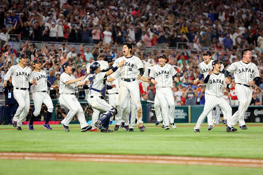 Het Japanse team bestormt Ohtani nadat hij Trout uitgooide voor de overwinning