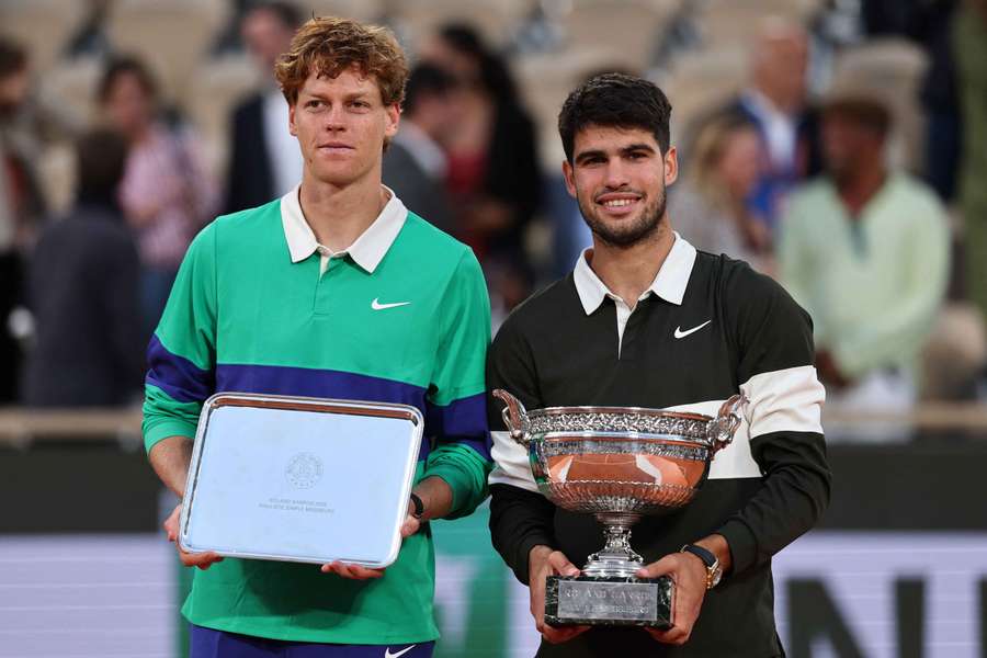 Carlos Alcaraz poses with the trophy after winning the men's singles final alongside runner-up Jannik Sinner