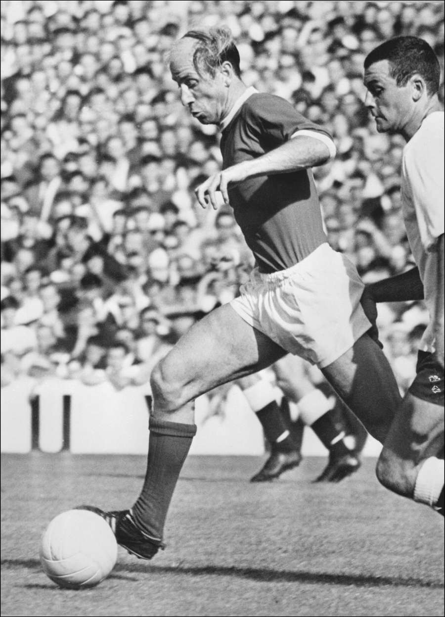 Bobby Charlton, campeão inglês de futebol, ultrapassa um defesa, 05 de dezembro de 1969