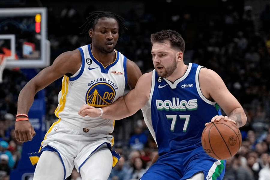 Luka Dončič (vpravo) postupuje s loptou cez Jonathana Kumingu.