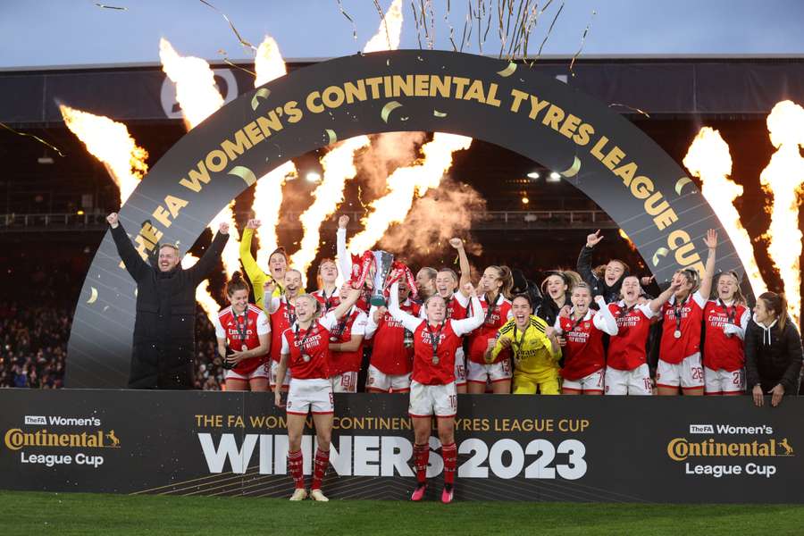 Arsenal's English defender Leah Williamson (L) and Arsenal's Scottish midfielder Kim Little lift the trophy