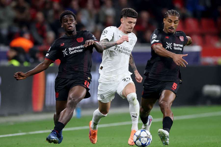 Dennis Man of PSV battling with Bayer Leverkusen's Ernest Poku (L) and Loic Bade