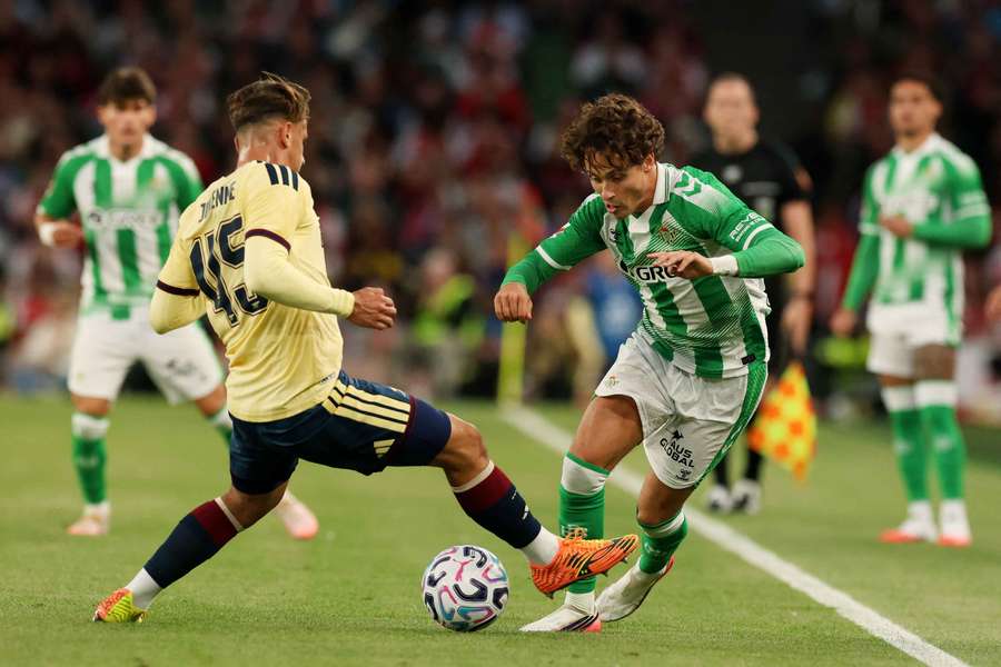 Arsenal's Theo Julienne in action with Real Betis' Rodrigo Riquelme