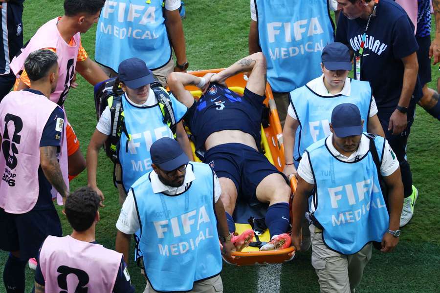 Uruguay's Manuel Ugarte looks dejected as he is stretchered off after sustaining an injury at the World Cup