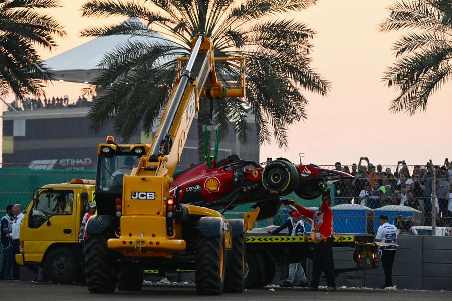 Stewards help remove the car of Ferrari's Carlos Sainz