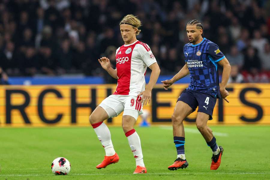 AFC Ajax Amsterdam forward Kasper Dolberg in possession, guarded by PSV Eindhoven defender Armando Obispo