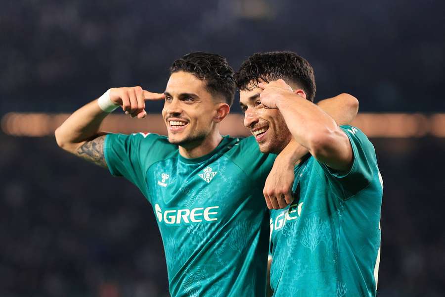 Marc Roca of Real Betis celebrates with teammate Marc Bartra after scoring his team's second goal against Real Sociedad