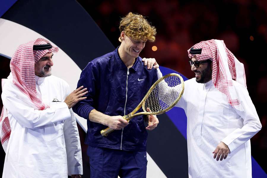 Jannik Sinner holding the golden tennis racket with Yasir Al-Rumayyan and Turki Al-Sheikh after the Six Kings Slam