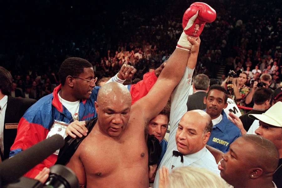 Referee Joe Cortez (R) holds George Foreman's arm up in victory after Foreman knocked Michael Moorer out