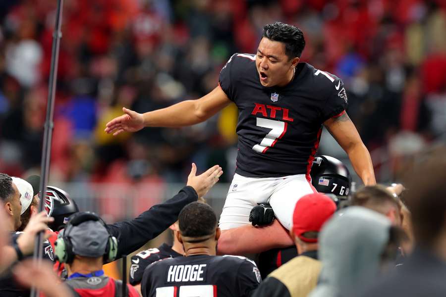 Falcons kicker Younghoe Koo wordt op handen gedragen na zijn winnende field goal in overtime tegen de Panthers