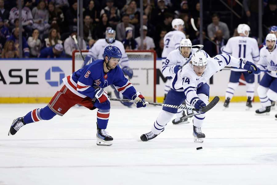 Toronto Maple Leafs centre Bobby McMann and New York Rangers defenceman Zac Jones battle for the puck in the first period
