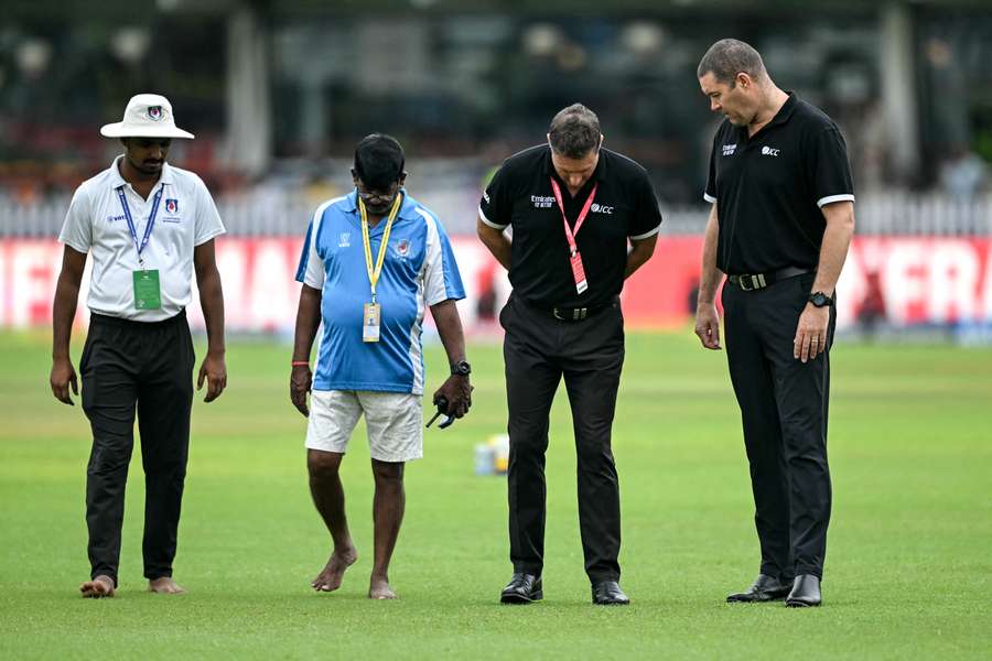 The umpires inspect the outfield on day three