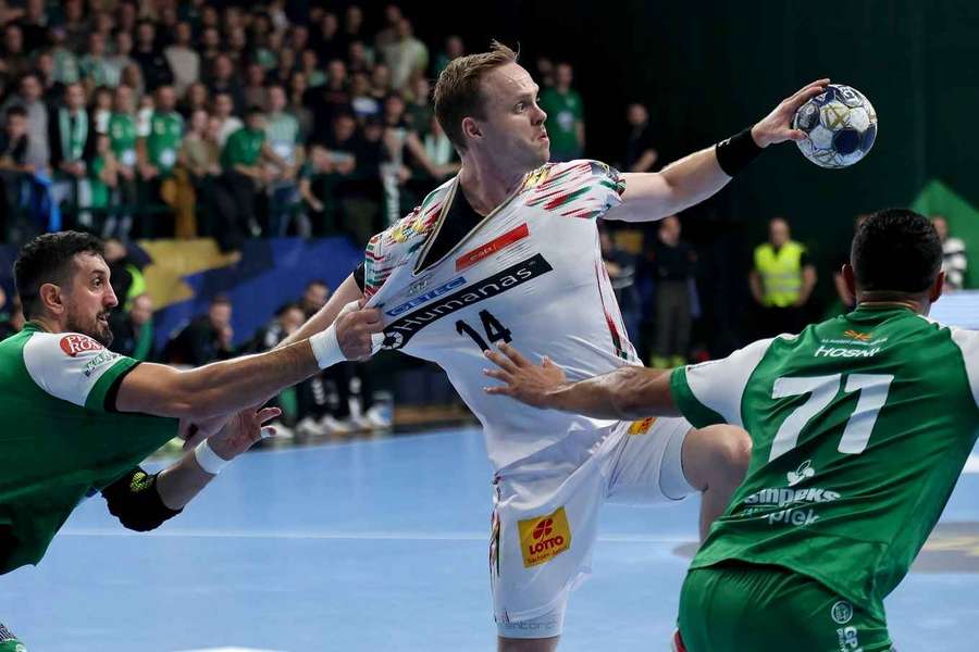 Omar Ingi Magnusson (m.) setzt sich gegen zwei Gegenspieler durch