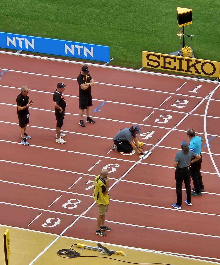 Officials inspect the track ahead of the evening session