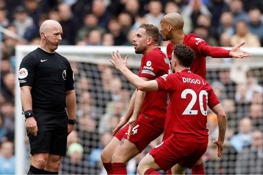 Liverpool players surround the referee